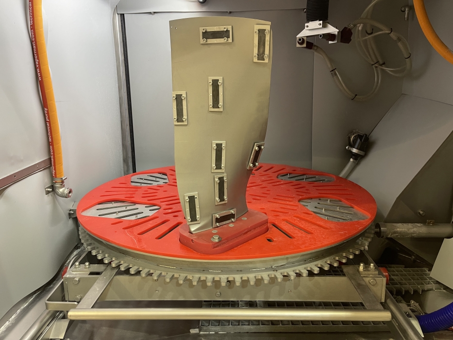 Fan blade fitted with Almen strips inside a Vapormatt Cougar+ vertical wet blasting machine